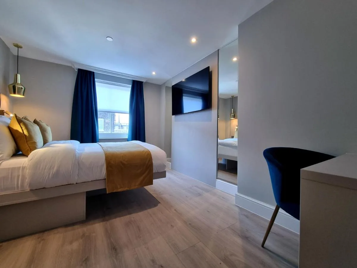 a hotel room with a bed and a desk at NOX Kensington Gardens in London