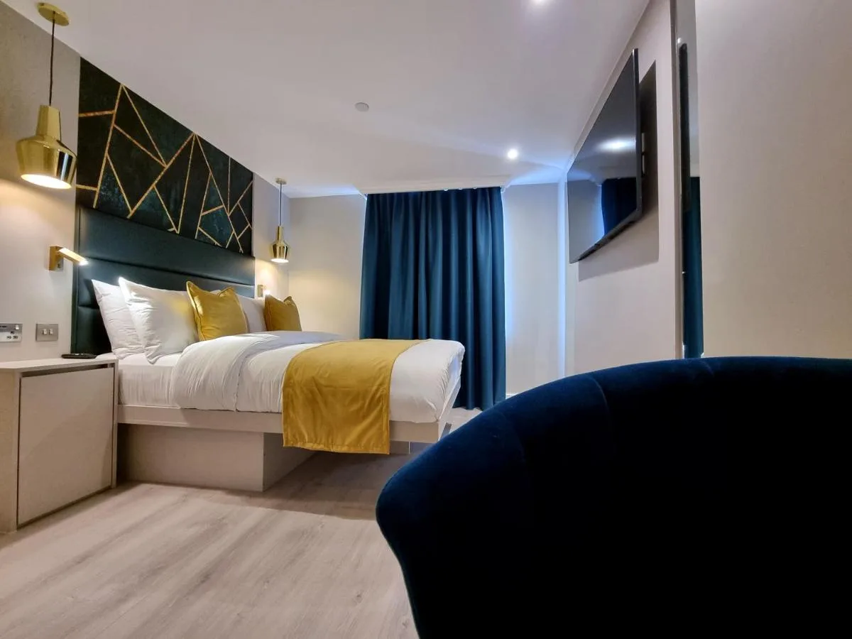 a hotel room with a bed and a couch at NOX Kensington Gardens in London